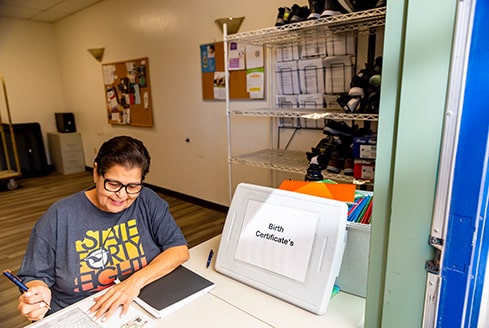 A volunteer working on birth certificates and other legal documents